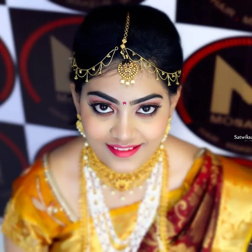 Close-up of a bride with gold jewellery and a maang tikka