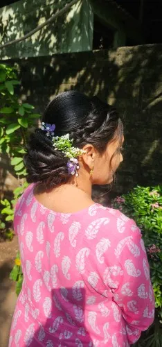 Low bun styled with small flower pins, seen from behind