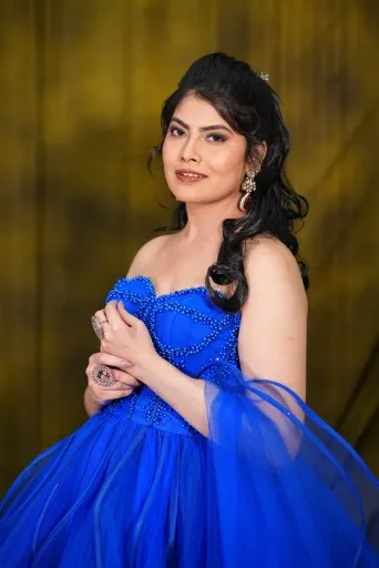 Model in a royal blue ball gown with soft curls