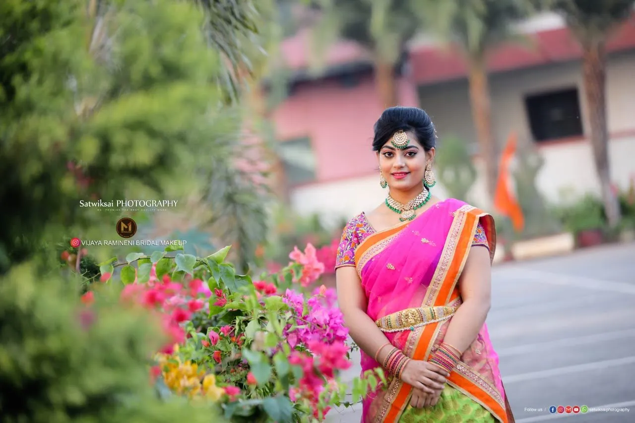 Model in a pink and orange saree in a flower garden