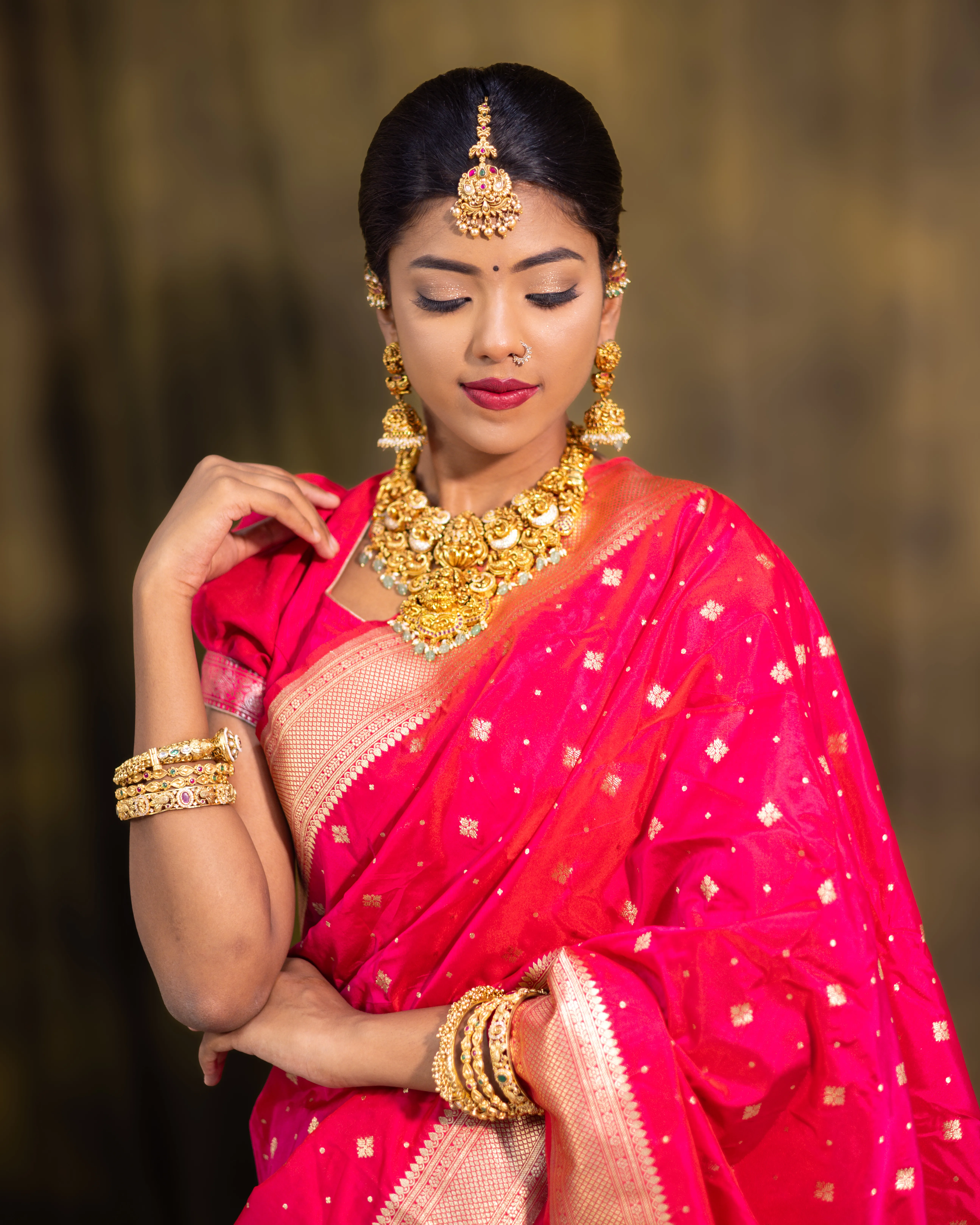 Model in a pink silk saree with gold temple jewellery