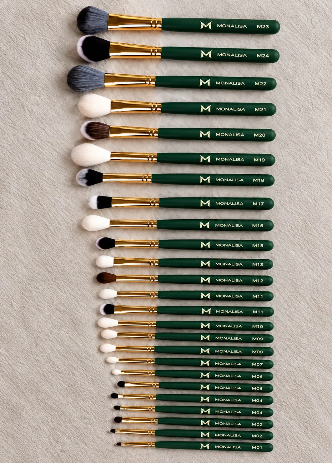 Set of green Monalisa makeup brushes laid out in a row